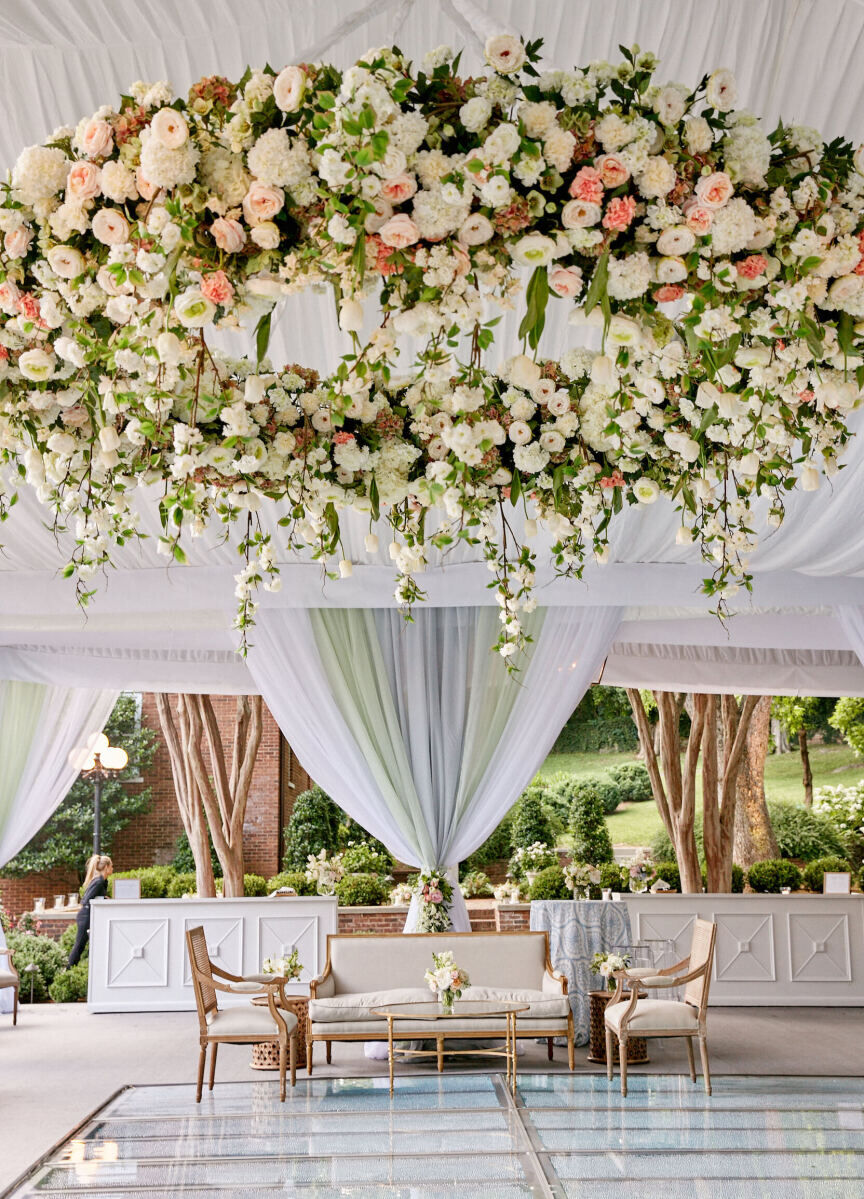Ceiling Wedding Decor: A circular floral hanging installation in a white tent.