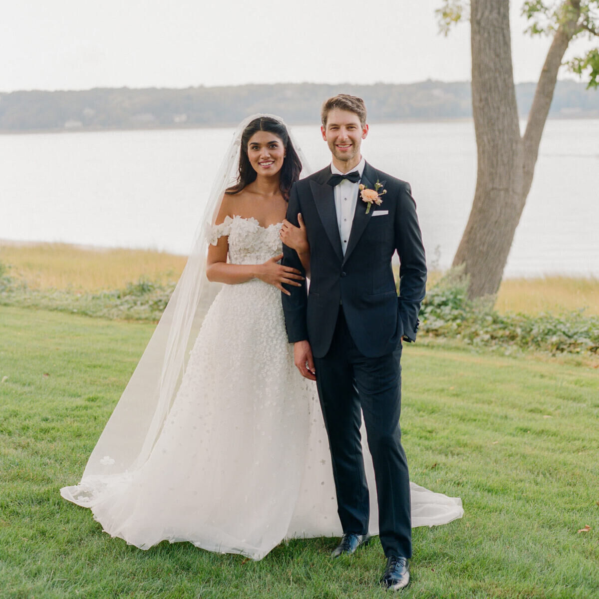 A bride and groom pose for a classic portrait at their waterfront wedding in New York.
