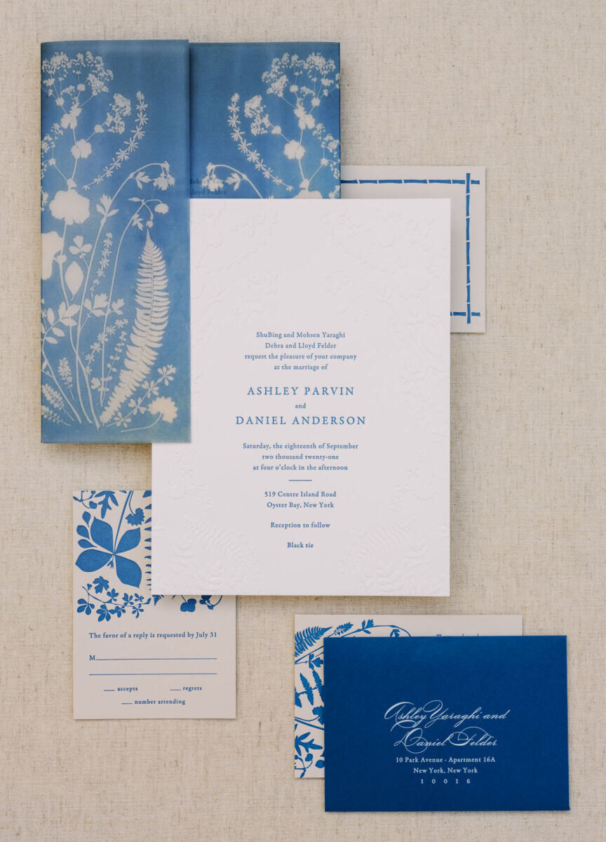 A floral wedding invitation in shades of blue and white set the scene for the waterfront wedding to come.