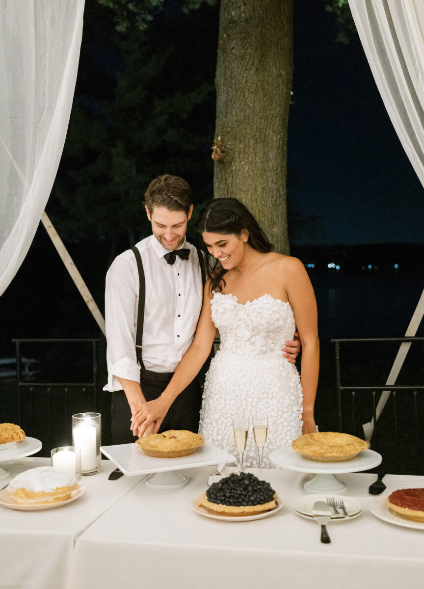 A groom and bride cut into pie instead of traditional wedding cake at their waterfront wedding at her parents' home.