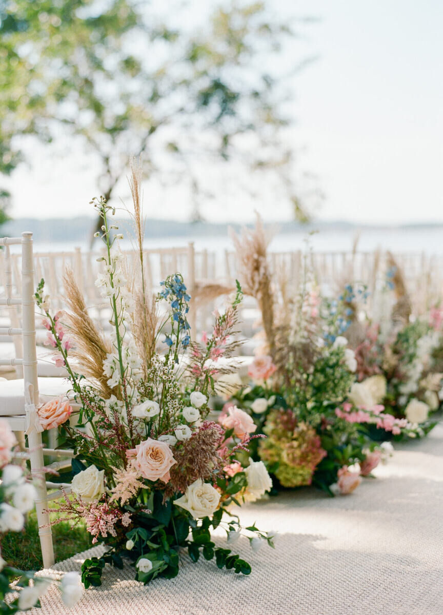 Pastel flower arrangements lined the aisle of this waterfront wedding ceremony in New York.