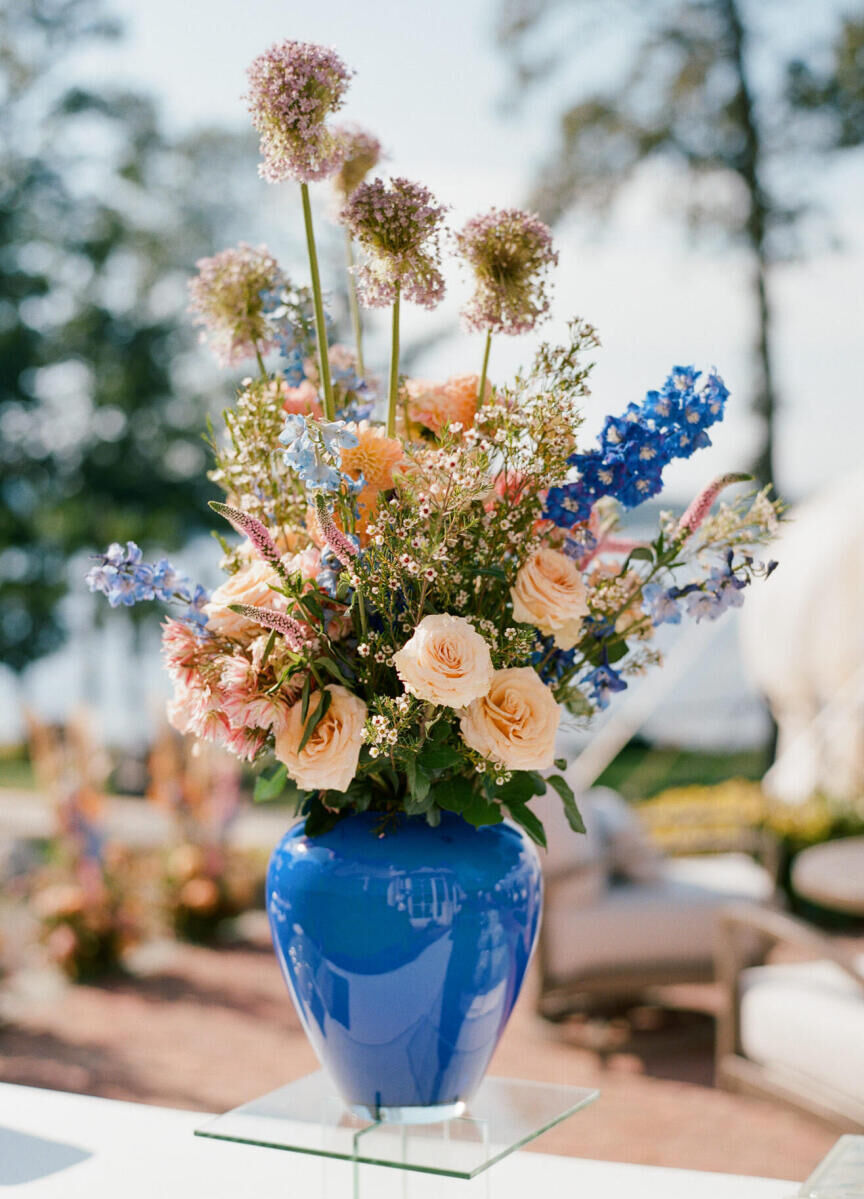 The flowers at cocktail hour of a waterfront wedding brought in pops of blue.
