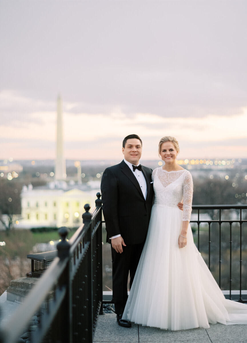 Wedding Tip: A smiling bride and groom standing on a balcony with the White House and Washington Monument seen in the background at dusk.