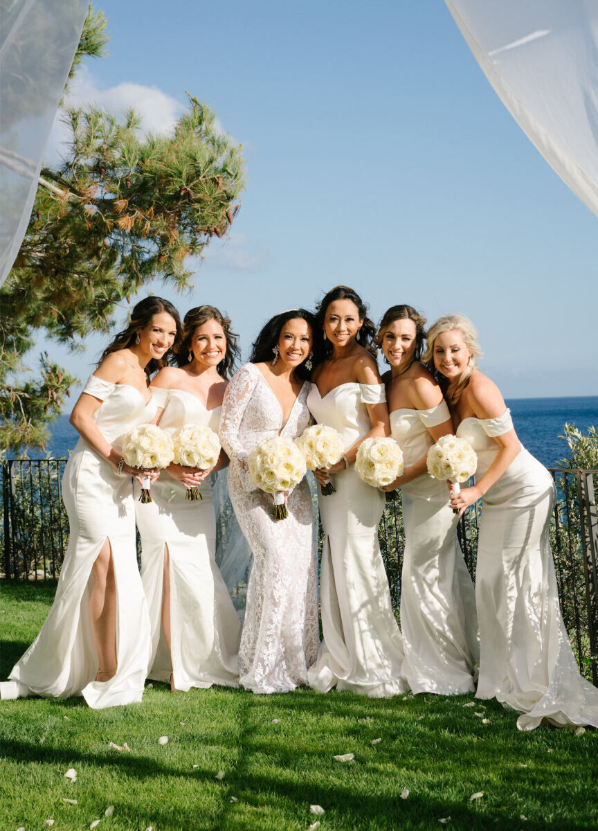 Wedding Tips:  A bride posing with her wedding party outside with the water in the background.
