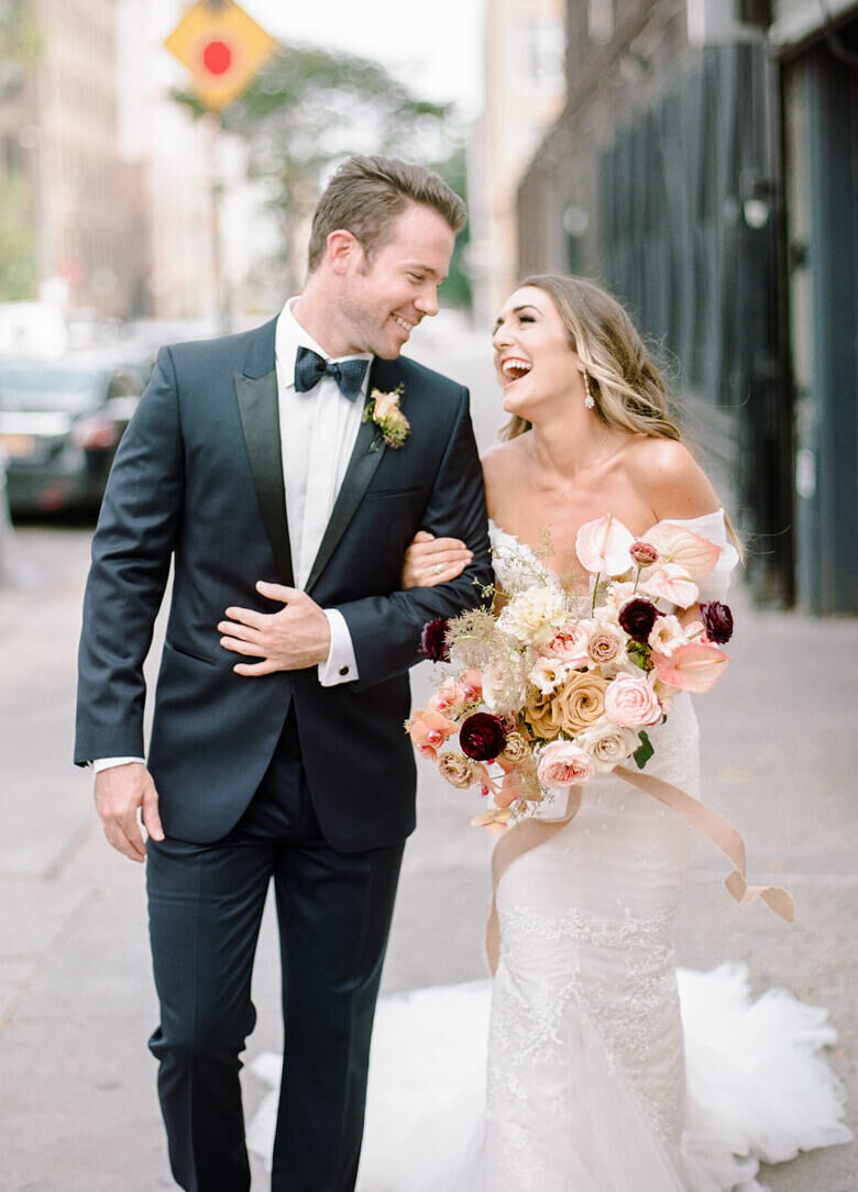 Wedding Tips: A bride and groom walking arm-in-arm, smiling, and walking down a sidewalk.