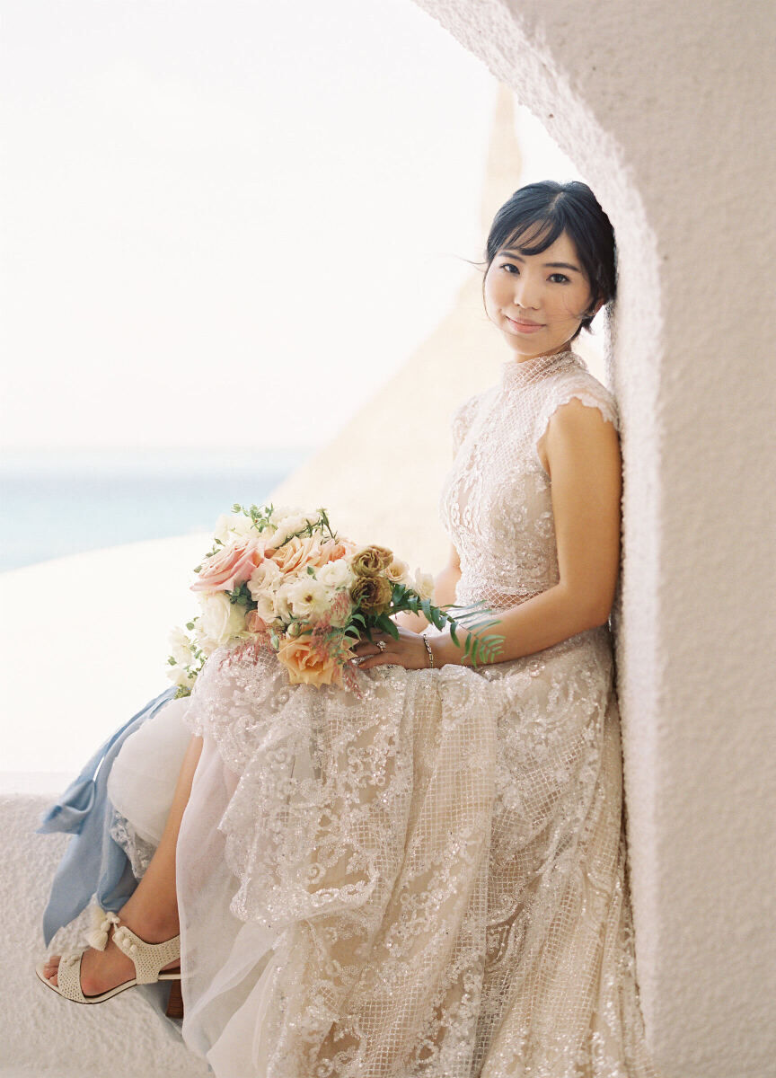 Wedding Tips: A bride sitting gracefully on a window ledge smiling softly.