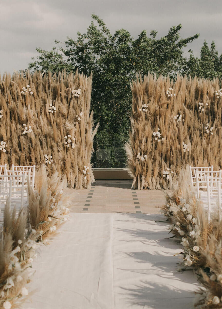 Wedding Tips: An outdoor wedding ceremony set-up made with lush beige fauna with white chairs in the audience area.