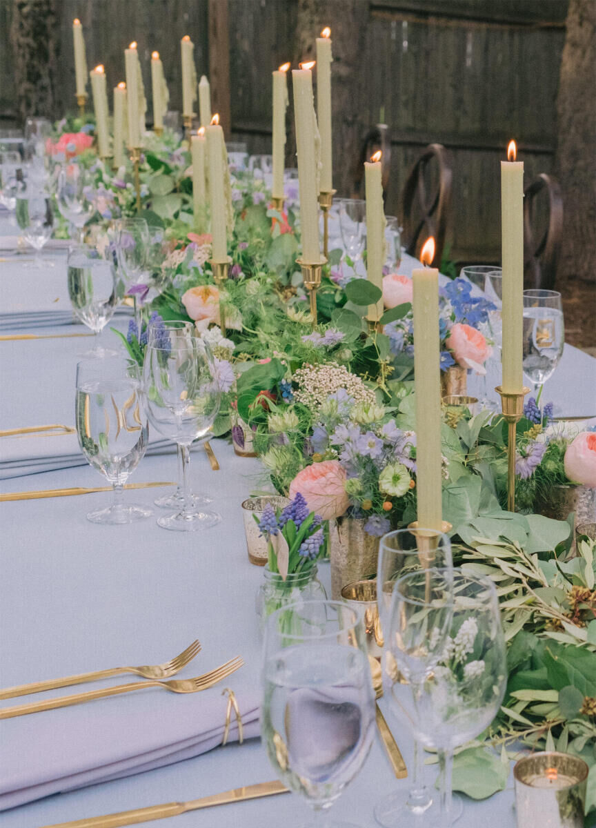 Wedding Tips: Close-up tablescape of a reception table set up with tall candles and pastel florals lining the middle.