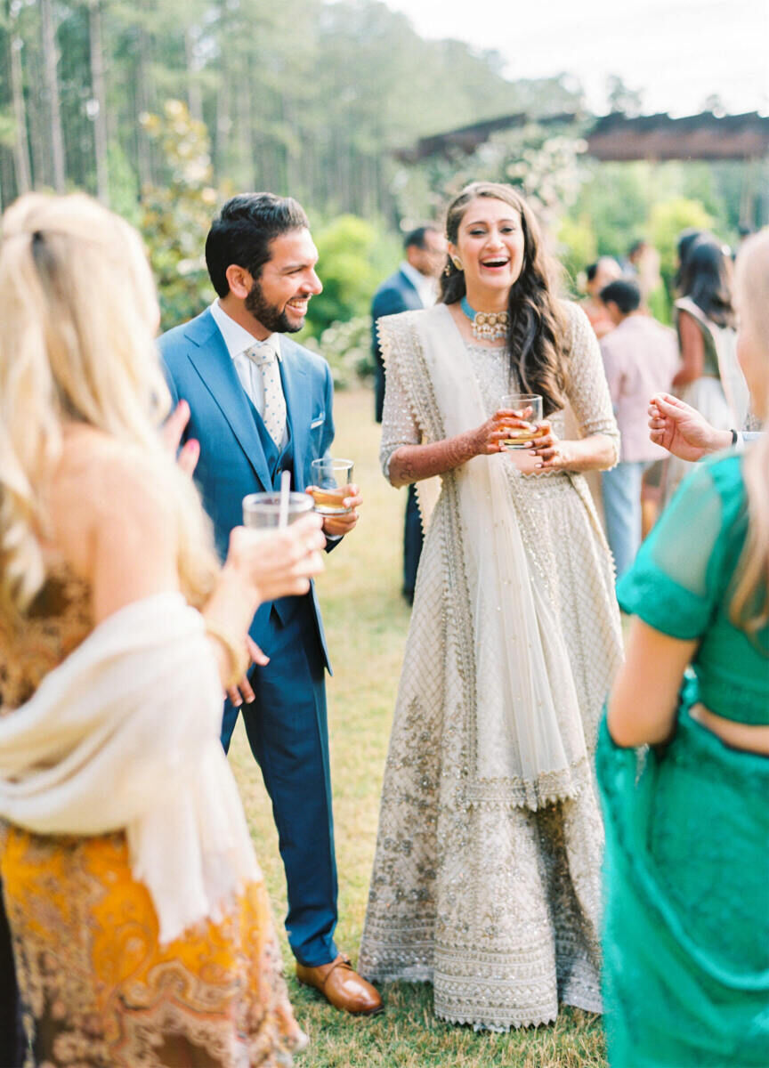 Wedding Tips: People laughing and holding drinks at an outdoor wedding celebration.